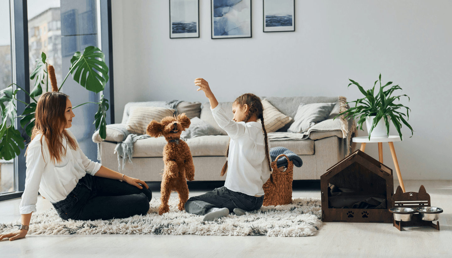 Happy family playing with dog at home